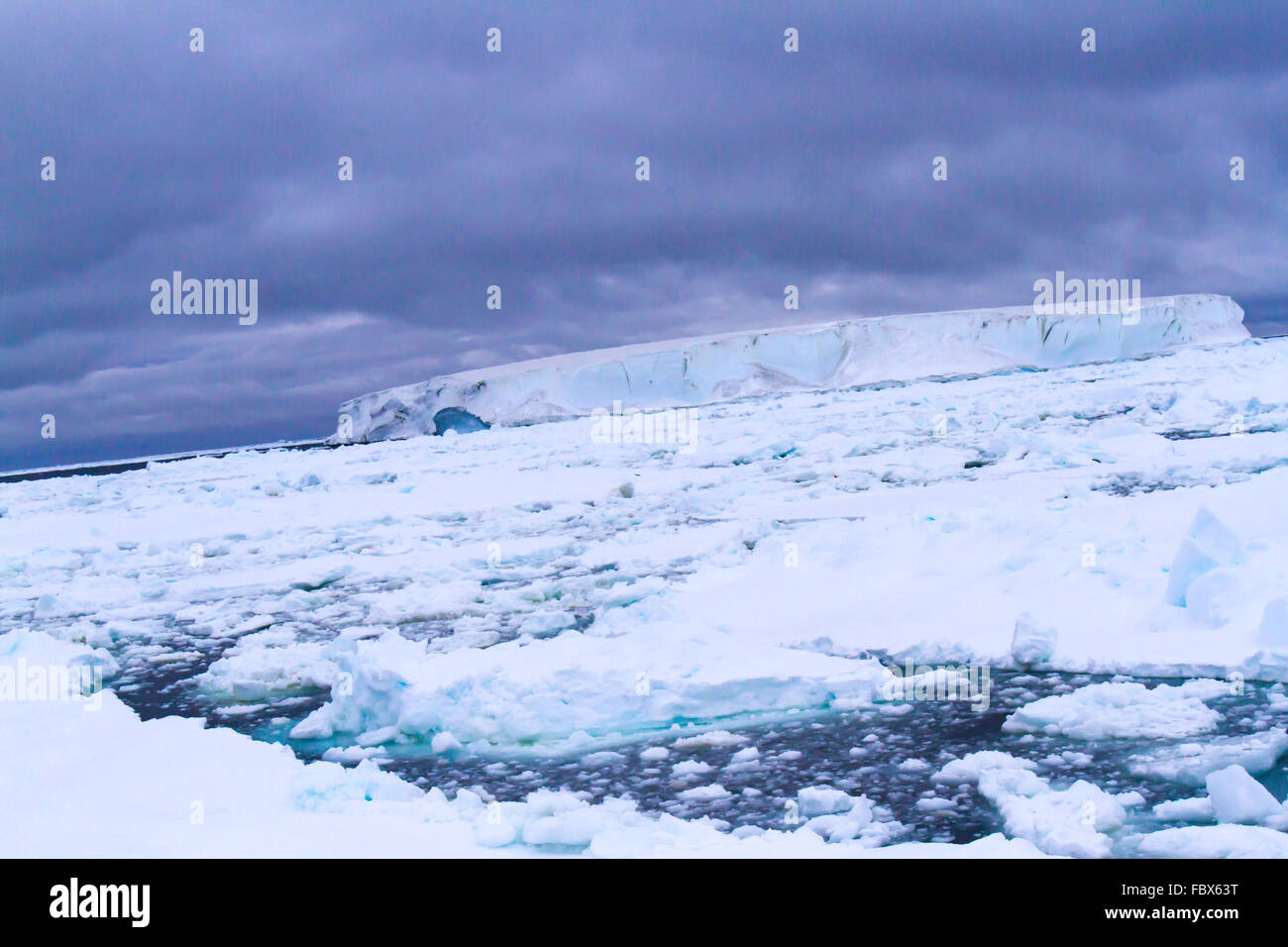 Tabellarischen Eisbergs in schwimmenden Eisfeld in der Antarktis Sonnenuntergang Landschaft. Stockfoto