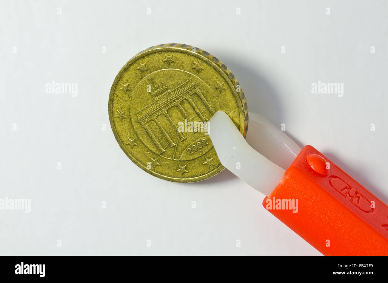 Zecken Zange halten deutsche zehn-Cent-Münze Stockfoto