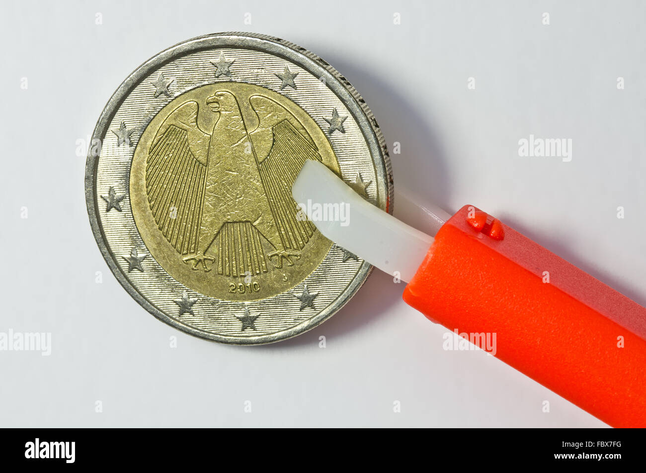 Zecken Zange halten deutsche 1 Euro Münze Stockfoto