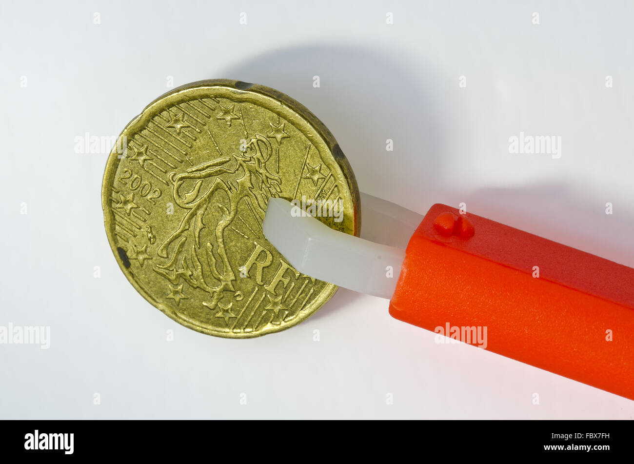 Zecken Zange halten französische 20 Cent-Münze Stockfoto