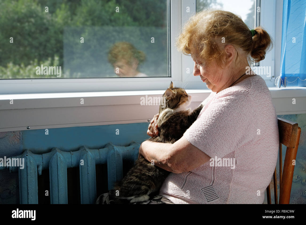 Die alte Frau hält Katze in einer Runde Stockfoto