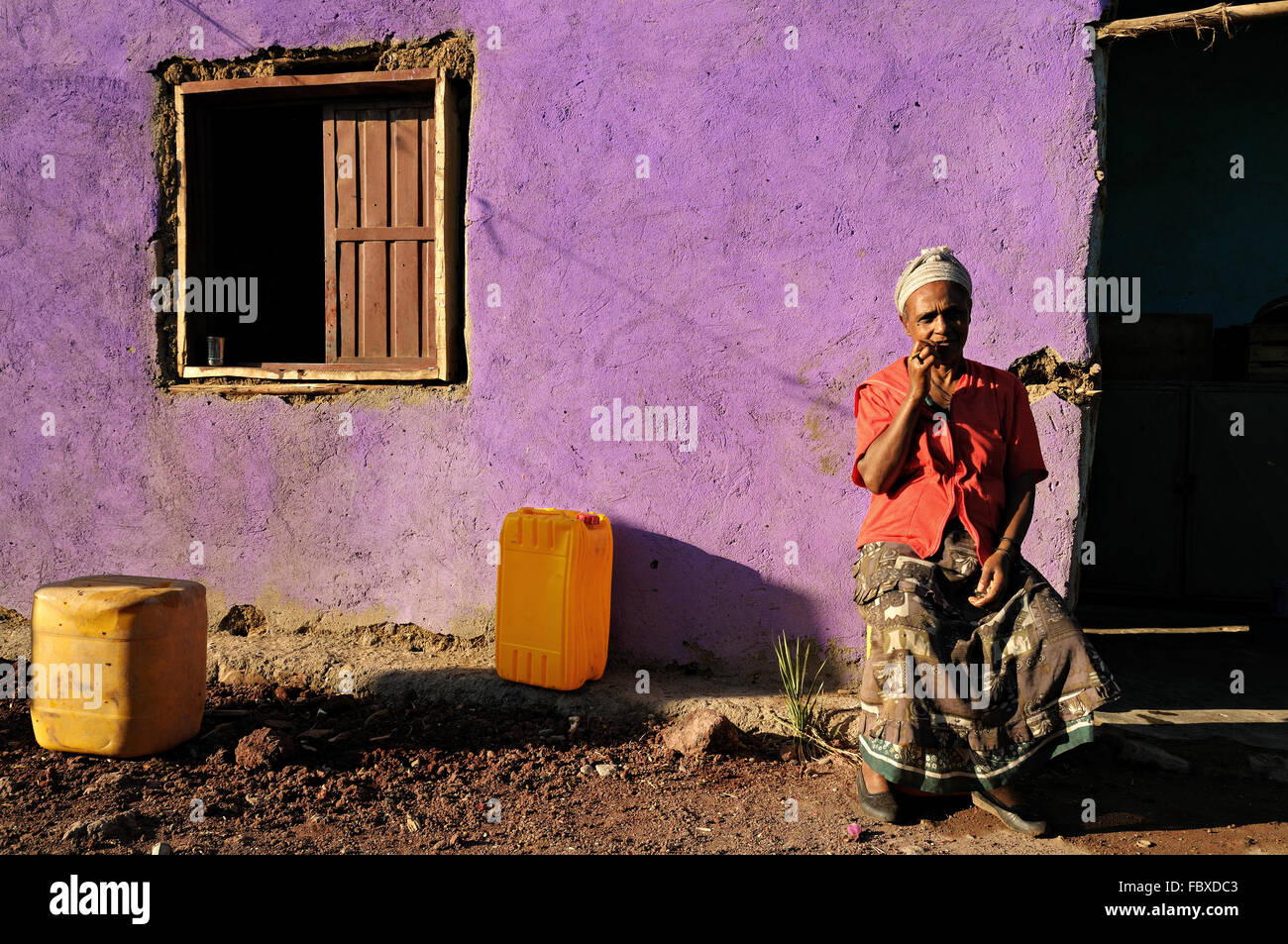 Afrikanische Reife Frau sitzt vor ihrem Haus in Logia (Logiya), Afar-Region, Äthiopien Stockfoto