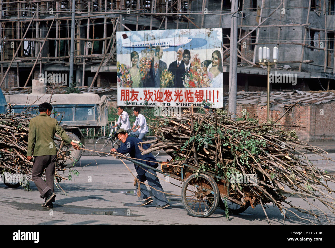 Menschenkraft Warenkorb Zugbelastung der Äste vor willkommen Yinchuan Poster, Yinchuan, autonomen Region Ningxia, China Stockfoto