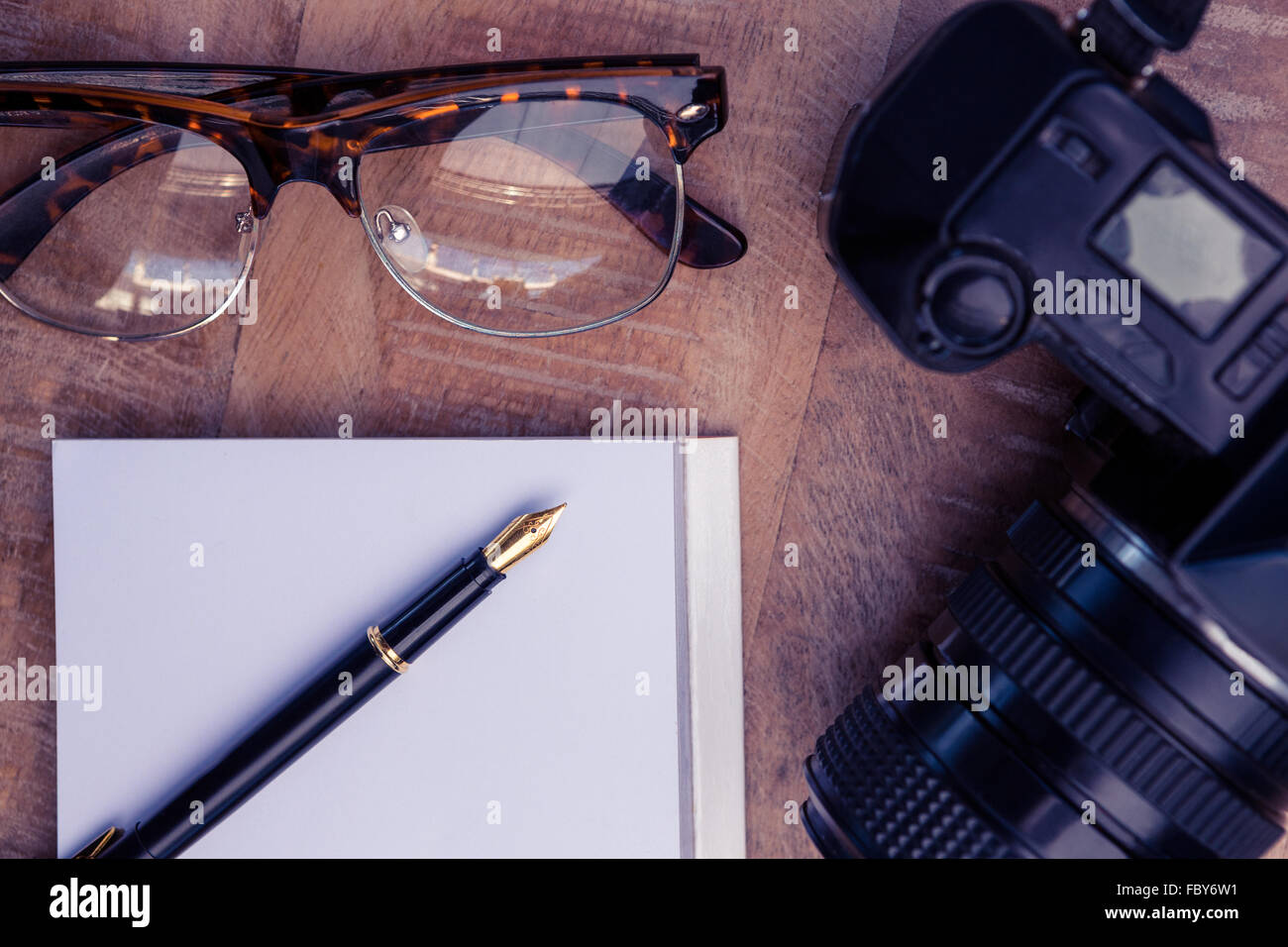 Stift auf Papier von Kamera und Auge Gläser am Tisch Stockfoto