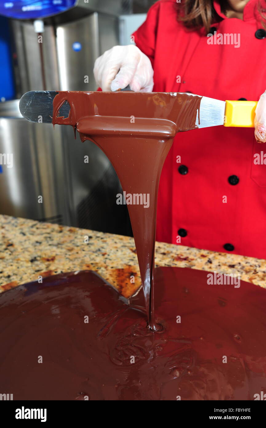Essen Süßigkeiten Schokolade macht Frau Temperieren von Schokolade auf einem kalten Marmor Tisch Stockfoto