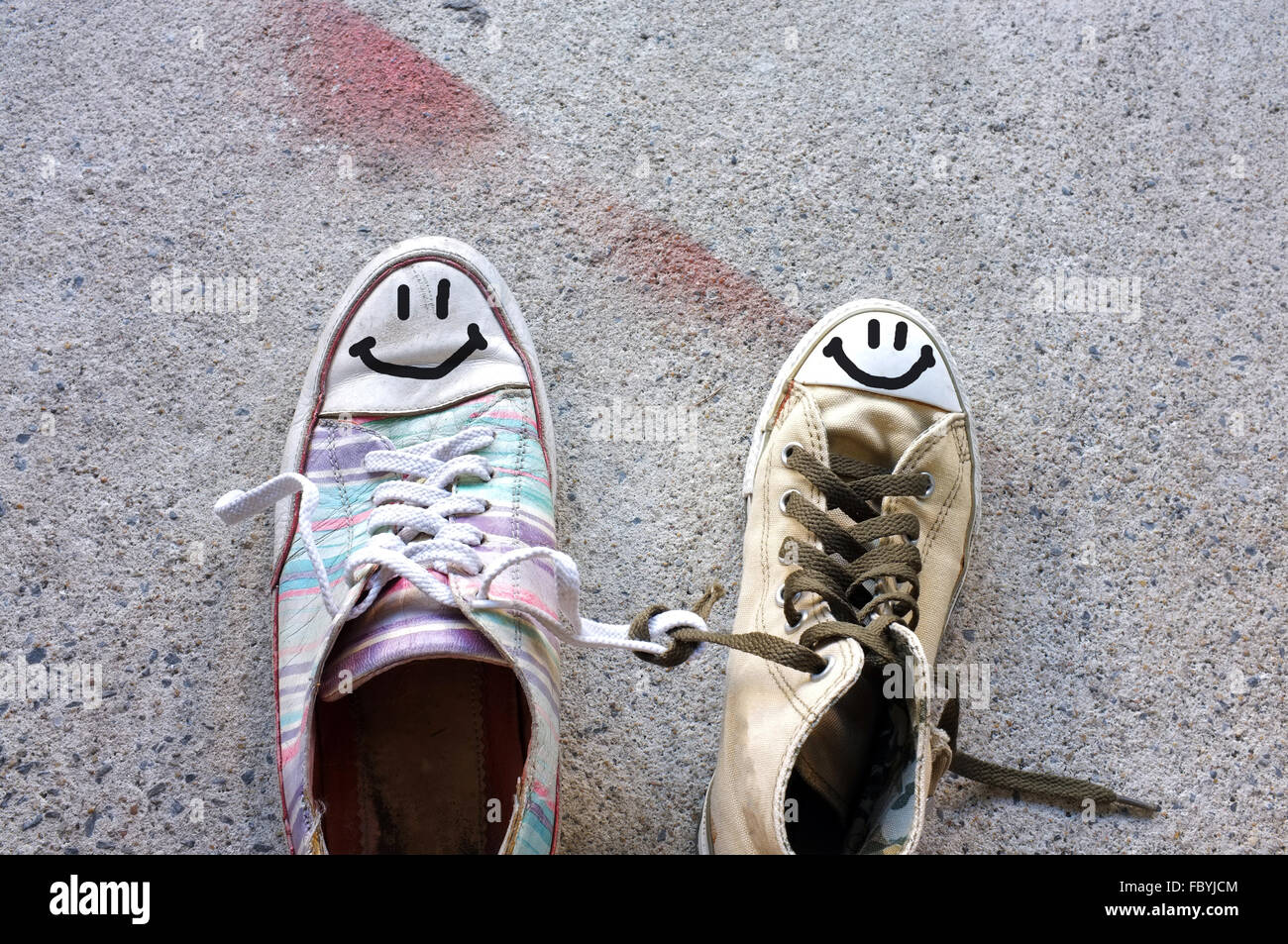 Bunte Sneakers mit Lächeln Gesicht auf Zement-Boden Stockfoto