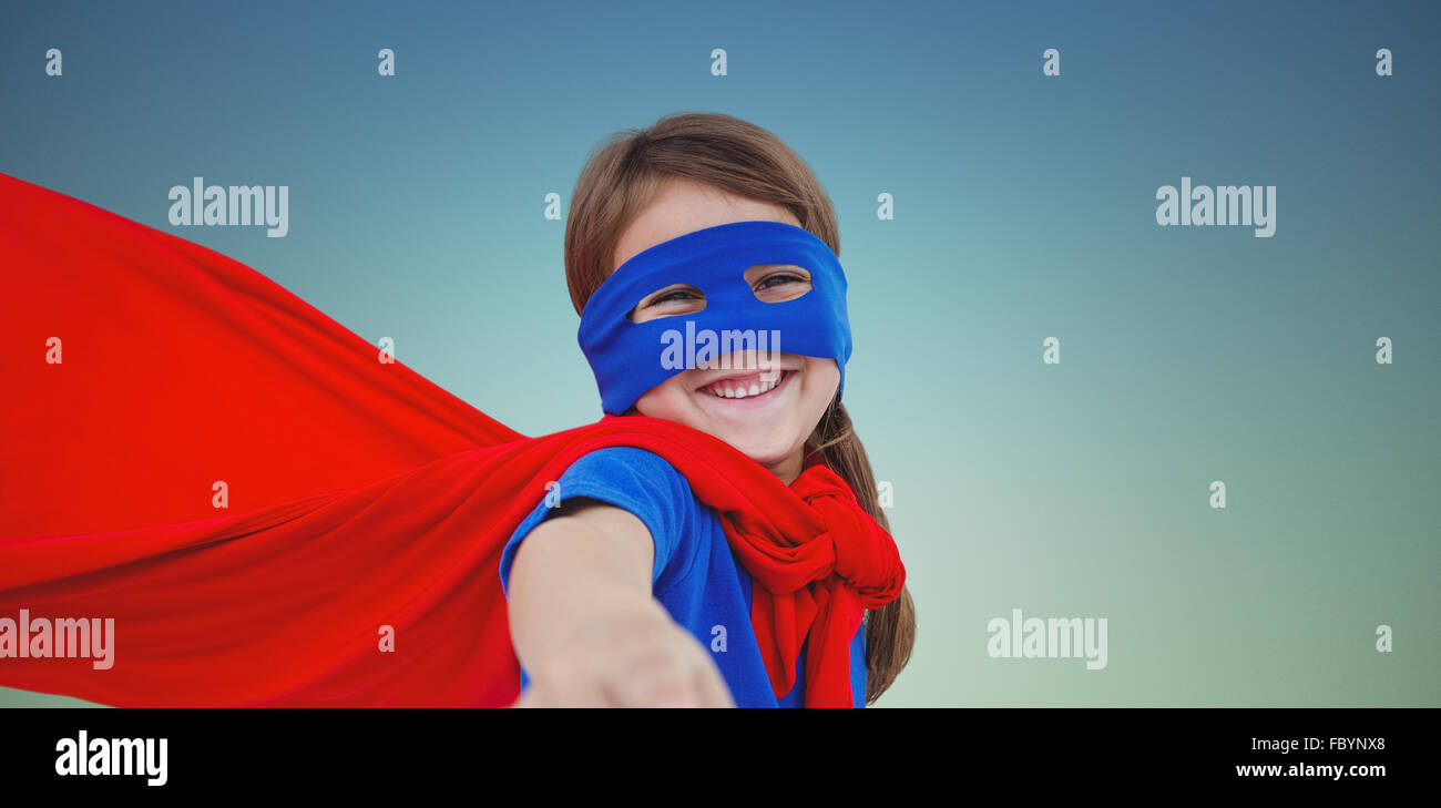 Zusammengesetztes Bild des lächelnden maskierten Mädchen vorgibt, Superheld zu werden Stockfoto