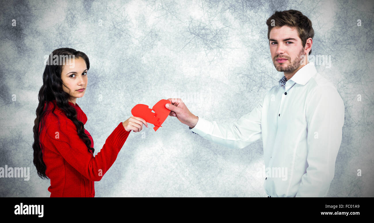 Zusammengesetztes Bild Porträt des Paares halten rote gebrochene Herzform Stockfoto