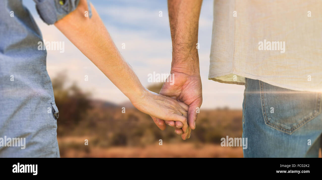 Zusammengesetztes Bild paar Holding Hände im park Stockfoto