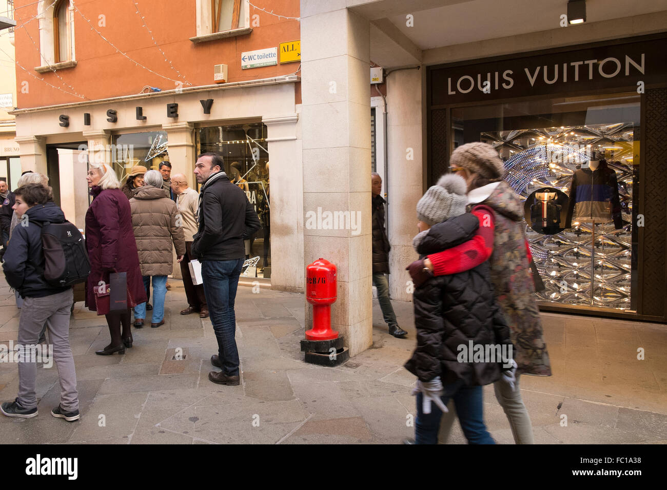 Menschen, die ein Spaziergang durch die Gassen von Venedig unter die Schaufenster von Luxus Stockfoto