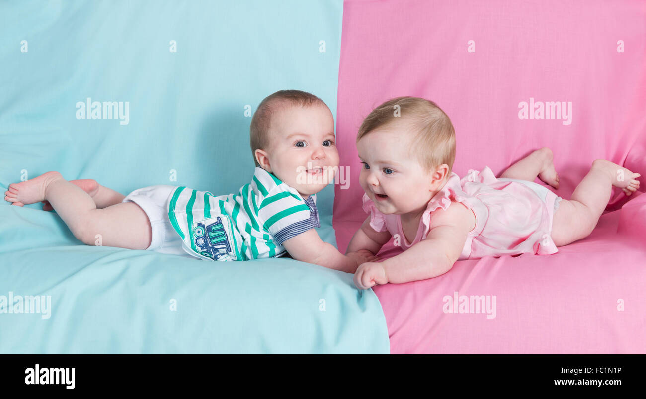 Bruder und Schwester - Zwillinge Babys Mädchen und Jungen auf rosa und blauen Hintergrund Stockfoto