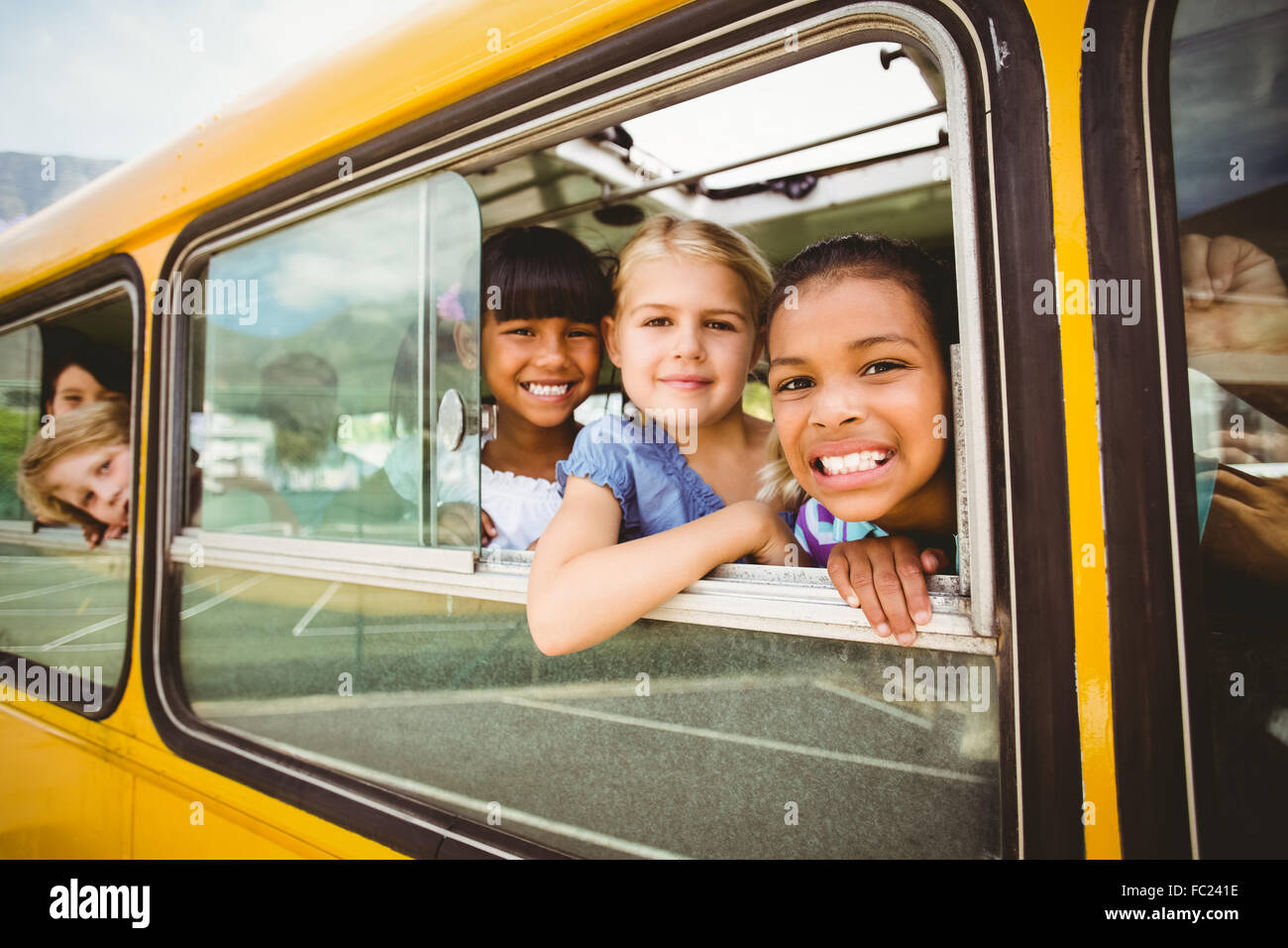 Niedlichen Schülerinnen lächelnd in die Kamera im Schulbus Stockfoto