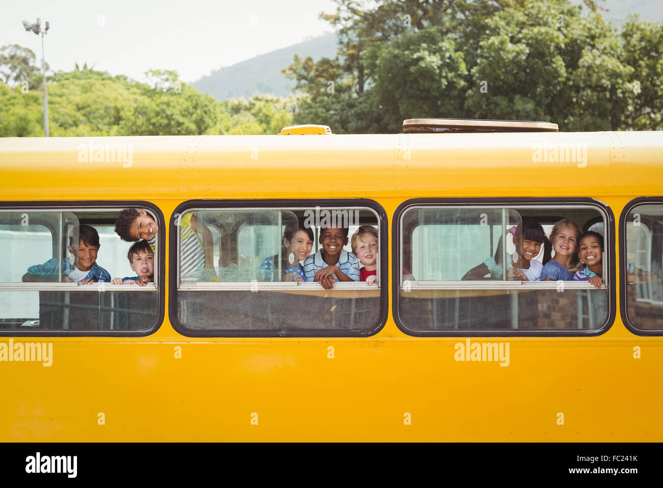 Niedlichen Schülerinnen lächelnd in die Kamera im Schulbus Stockfoto