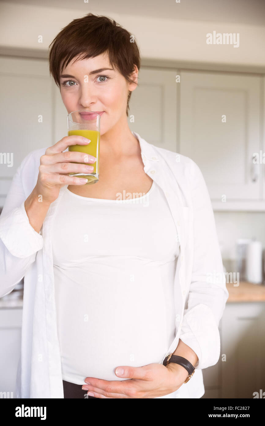 Schwangere Frau Glas Orangensaft trinken Stockfoto