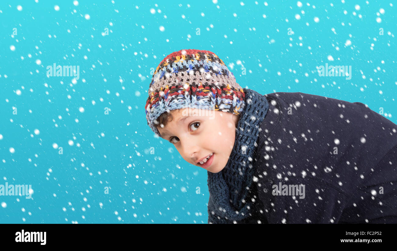 Winter - niedlichen kleinen Jungen unter fallenden Schnee Stockfoto