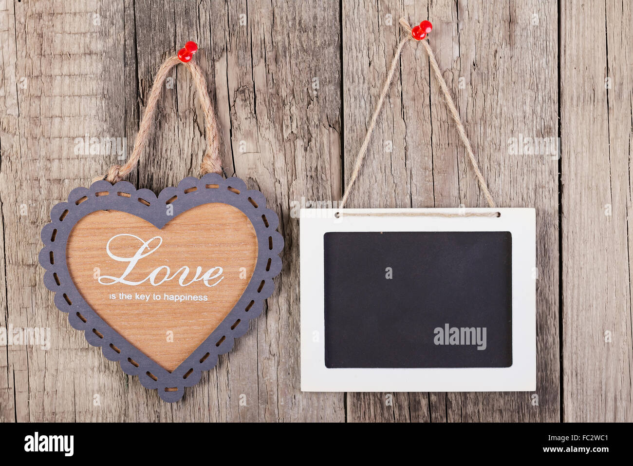 Leere hölzerne Tafel Zeichen und Herz Formrahmen mit Liebe Text auf hölzernen Hintergrund. Stockfoto