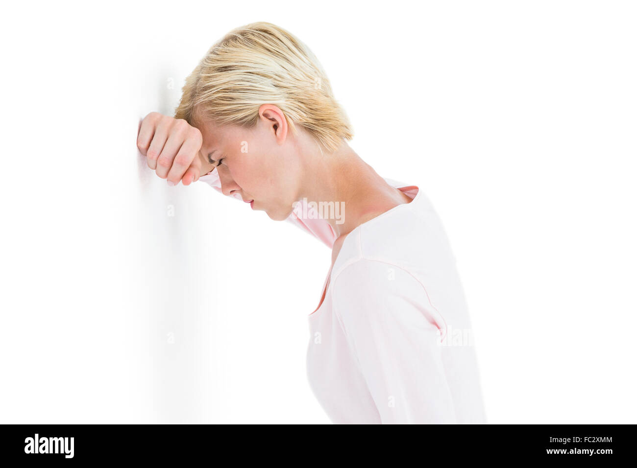 Nervös blonde Frau an die Wand gelehnt Stockfoto