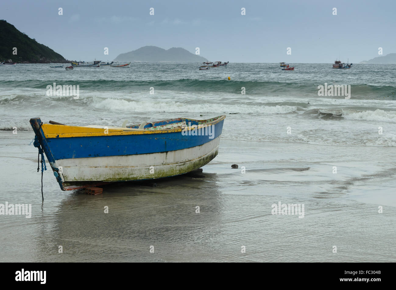 alte hölzerne Fischerboot am Strand bei Sonnenuntergang Stockfoto