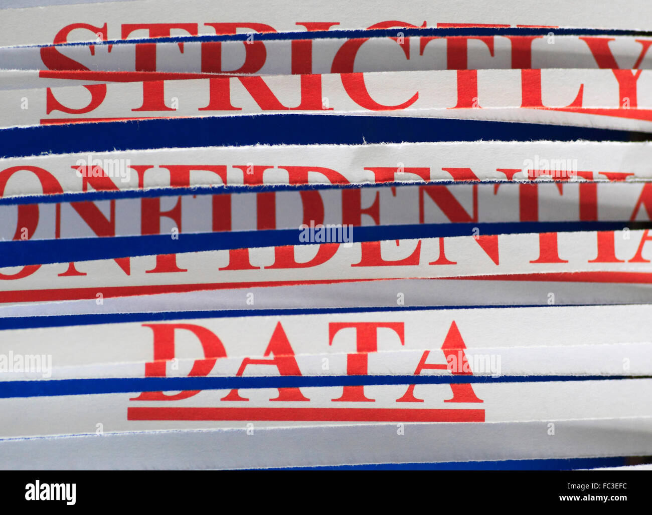 "Streng vertrauliche Daten" Papier durch einen Schredder. Stockfoto
