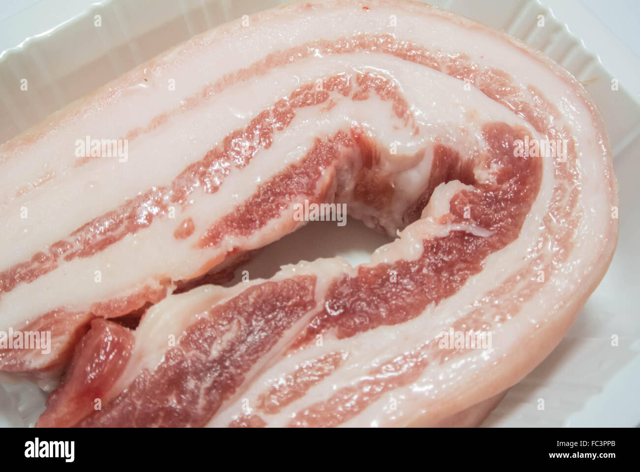 durchwachsenem Schweinefleisch in Plastikschale Paket selektiven Fokus Stockfoto