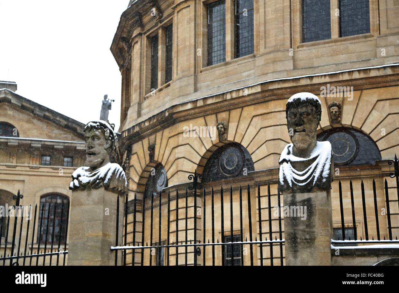 Zwei von den römischen Kaisern Köpfe außerhalb das Sheldonian Theatre in Oxford mit eine leichte Decke von Schnee. Stockfoto