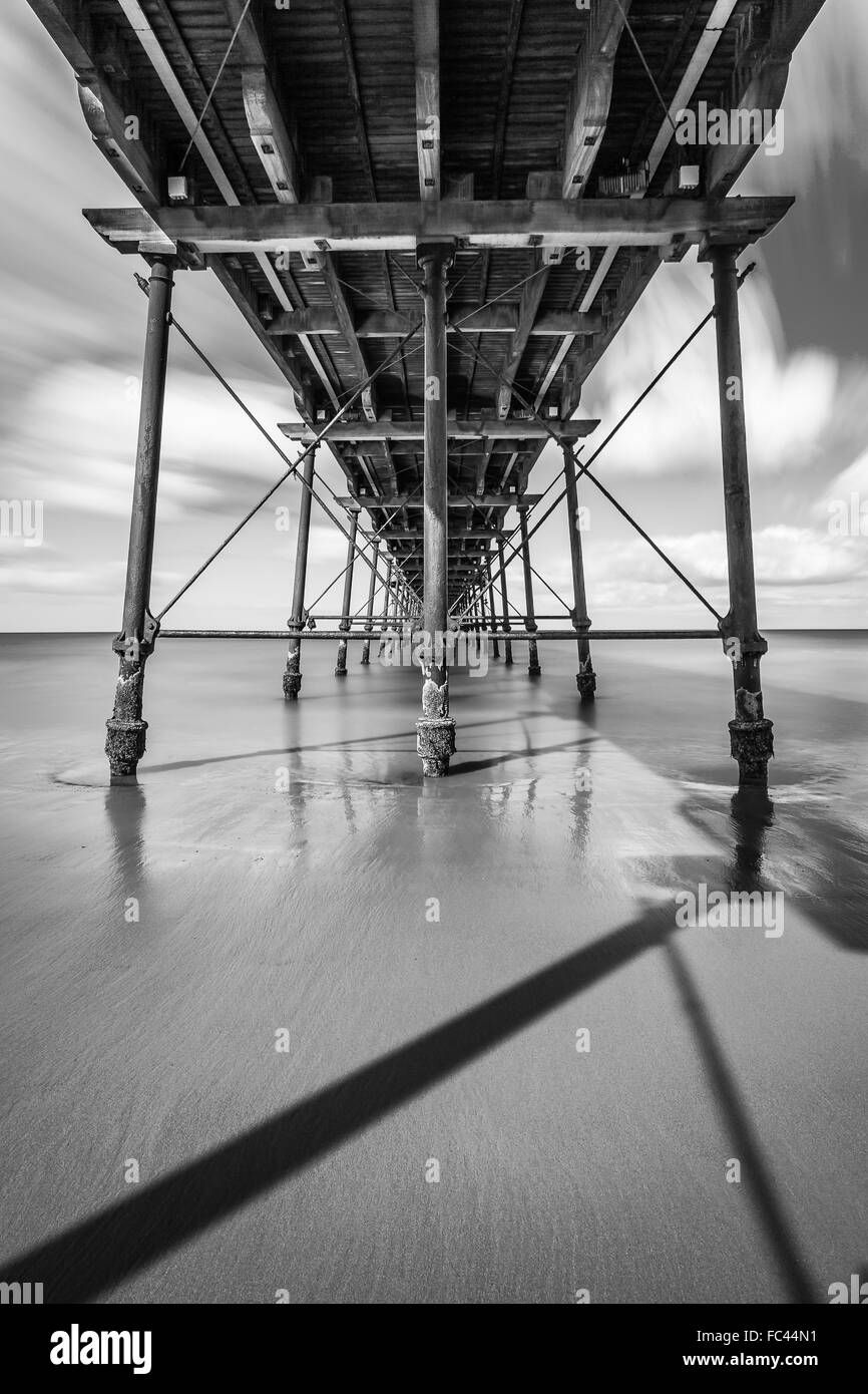 Monochrome Langzeitbelichtung zu erfassen, unter dem Pier im Saltburn am Meer Stockfoto