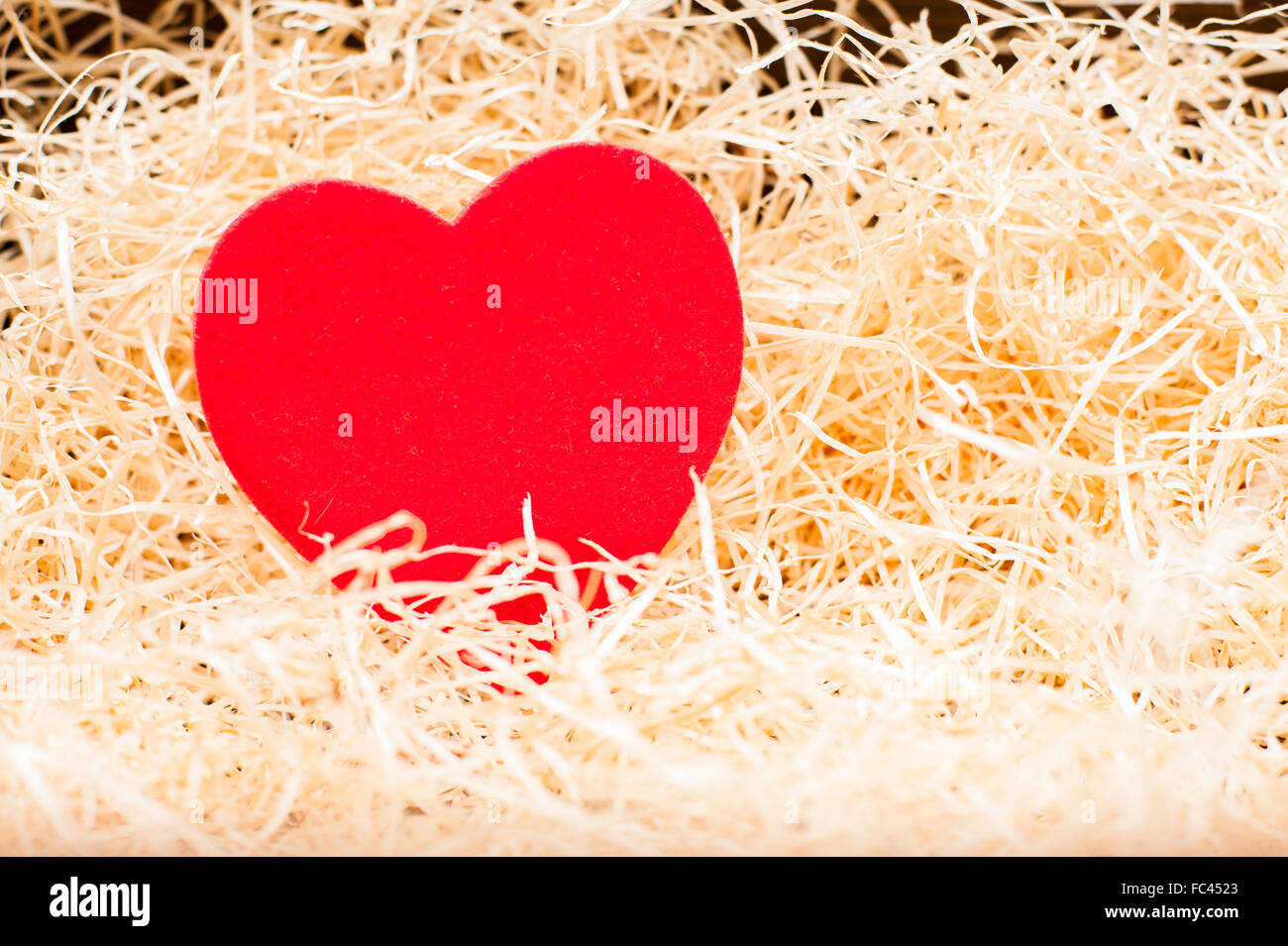 Liebe Wiege mit roten Herz auf gelbes Stroh Teppich selektiven Fokus Stockfoto