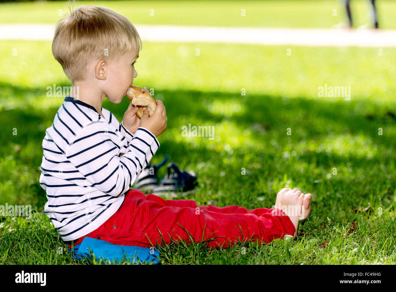 Vorschule Bubi Brot außerhalb essen Stockfoto