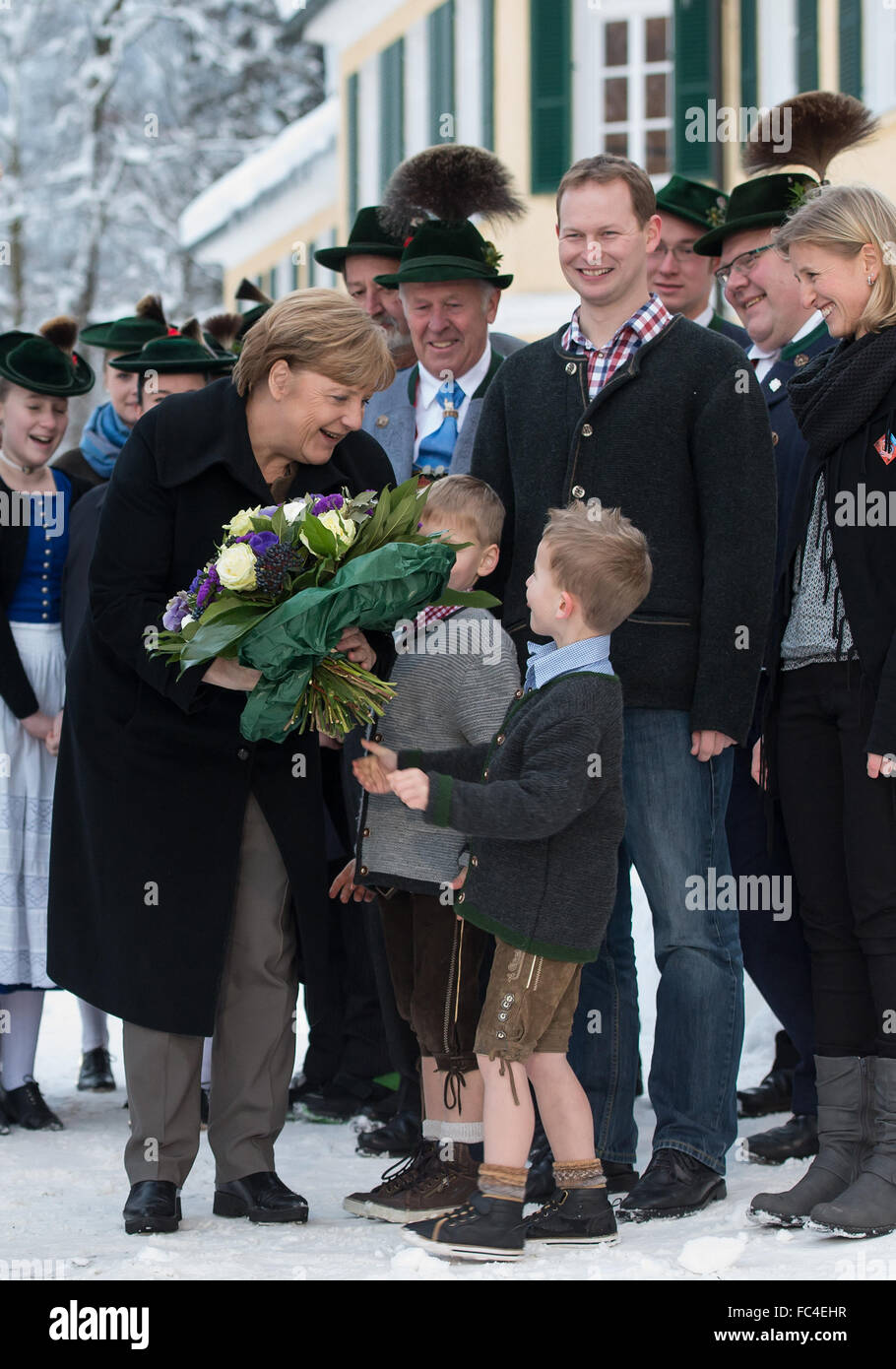 Kreuth, Deutschland. 20. Januar 2016. RECROP - die deutsche Bundeskanzlerin Angela Merkel wird von einer Folkloregruppe in traditionellen Kostümen vor dem Konferenzgebäude der Winter Konferenz der die CSU-Staat in Kreuth, Deutschland, 20. Januar 2016 begrüßt. Die geschlossene Tür Treffen der die CSU-Zustand wird in der Bildungseinrichtung der Hanns Seidel Stiftung in Wildbad Kreuth vom 18. bis 21. Januar 2016 stattfinden. Foto: SVEN HOPPE/DPA/Alamy Live-Nachrichten Stockfoto