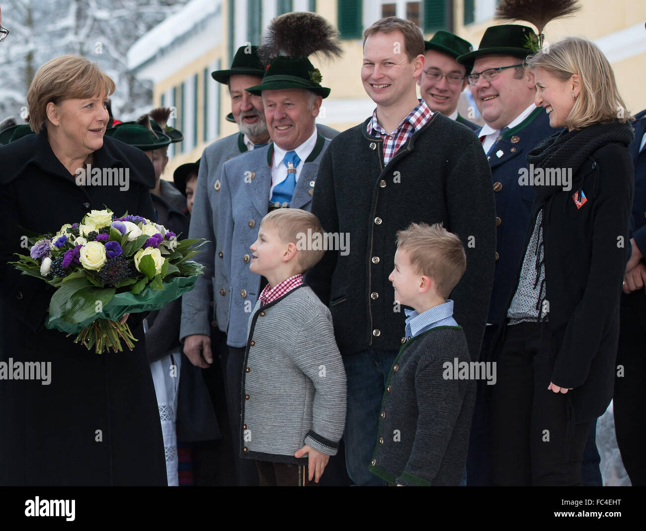 Kreuth, Deutschland. 20. Januar 2016. RECROP - die deutsche Bundeskanzlerin Angela Merkel wird von einer Folkloregruppe in traditionellen Kostümen vor dem Konferenzgebäude der Winter Konferenz der die CSU-Staat in Kreuth, Deutschland, 20. Januar 2016 begrüßt. Die geschlossene Tür Treffen der die CSU-Zustand wird in der Bildungseinrichtung der Hanns Seidel Stiftung in Wildbad Kreuth vom 18. bis 21. Januar 2016 stattfinden. Foto: SVEN HOPPE/DPA/Alamy Live-Nachrichten Stockfoto