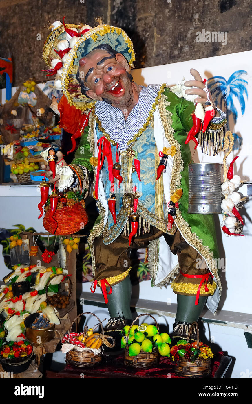 Neapel, via San Gregorio Armeno. Statue von Pazzariello. 'O Pazzariello war ein Streetart-Künstler, Figur und weit verbreitete Funktion von Neapel des späten 18. Jahrhunderts, 19. und der ersten Hälfte des' 900, eine Art von Jester Quadrat die Passanten mit seiner schrulligen kleinen Show angezogen. In der Regel konnte man es in den Straßen, gekleidet in einen sehr auffälligen, mit Wein oder andere Produkte (in der Regel Brot und Nudeln) anvertraut, die einem nahe gelegenen Keller oder Werkstatt selbst zu fördern. Die Pazzariello war auch der Zauber gegen den bösen Blick. Stockfoto