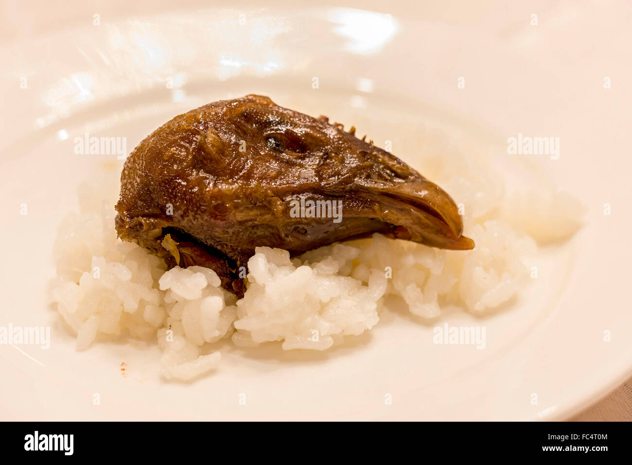 Gegrilltes Huhn Kopf serviert auf einem Bett aus Reis in einem Restaurant in China. Stockfoto