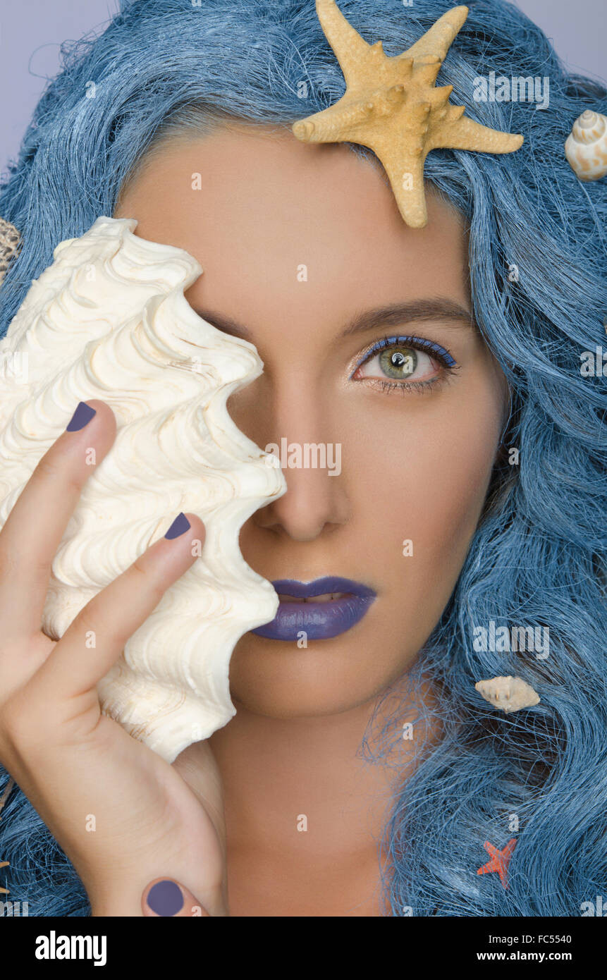 Frau mit blauen Haaren, Muscheln und offenen Augen Stockfoto