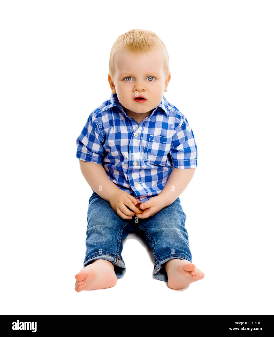 kleiner Junge in einem karierten Hemd und jeans Stockfoto
