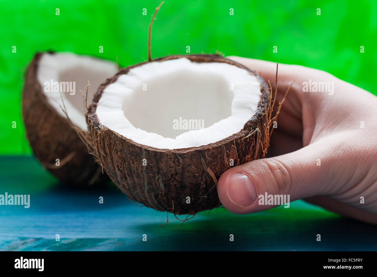 Kokosnuss-Hälften auf einem blau-grünen Hintergrund Stockfoto