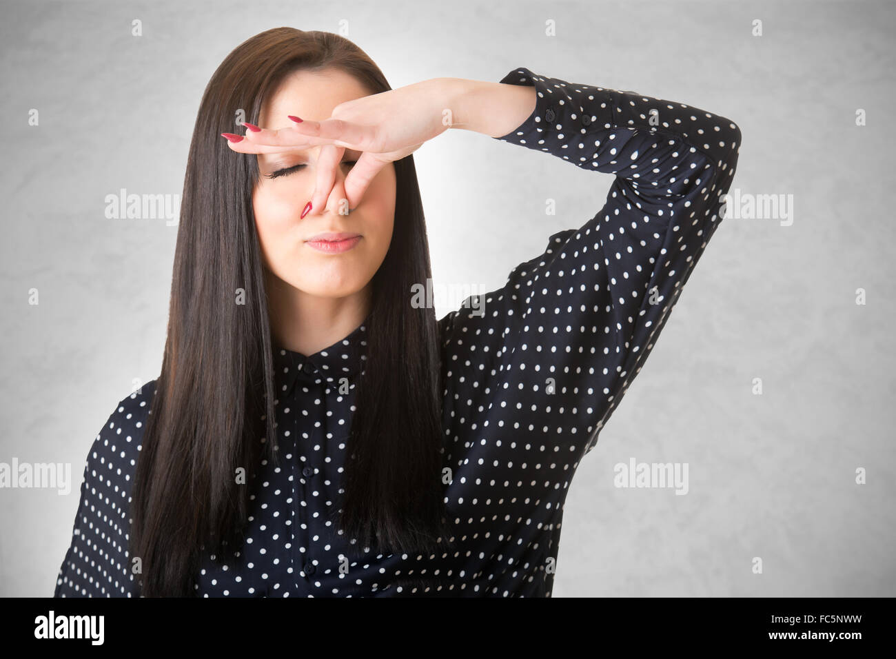 Weibchen mit ihrer Nase mit der Hand, in einem dunklen Hintergrund isoliert Stockfoto