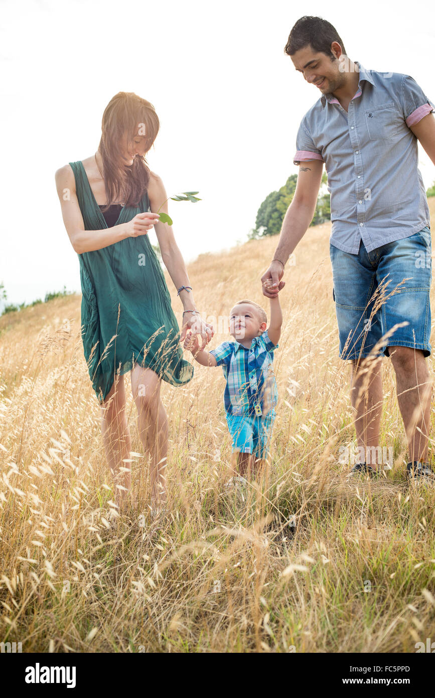 Glückliche Eltern gehen mit jungen Sohn im Feld Stockfoto