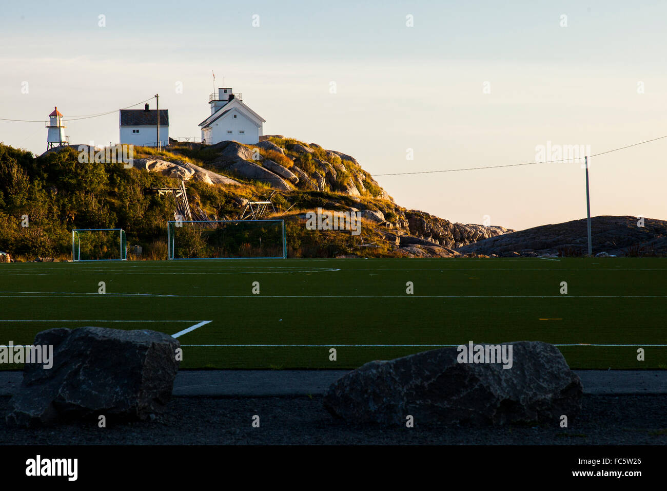 Fußballfeld vor einem Leuchtturm in Henningsvær (wieder) auf den Lofoten in Norwegen. Stockfoto