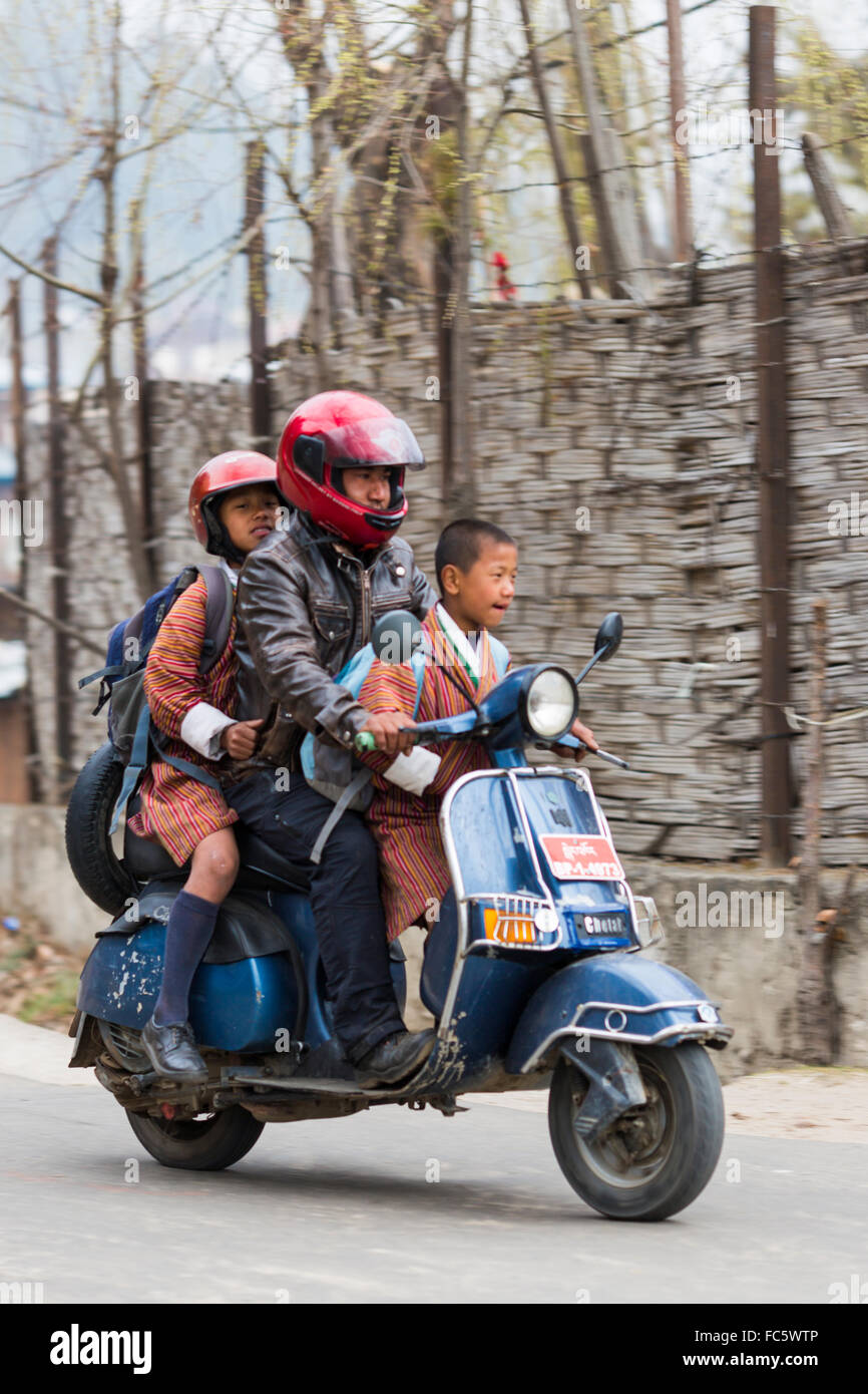Der Mensch nimmt zwei Söhne zur Schule auf Motorroller, Jakar, Bumthang, zentrale Bhutan, Asien Stockfoto