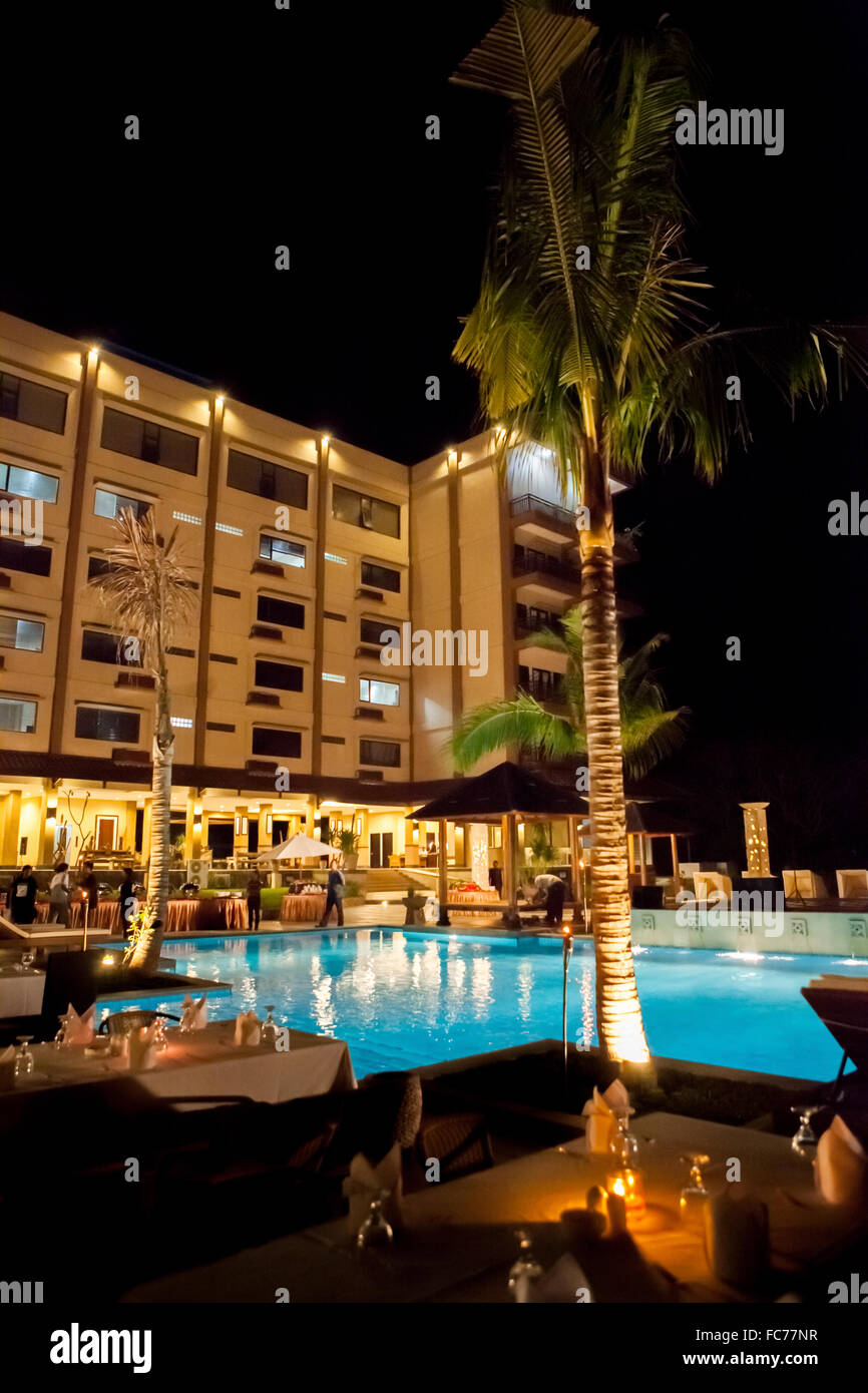 Nachtaufnahme von Pool und Esstischen zu Jayakarta Suiten, Labuan Bajo, Insel Flores, Indonesien. Stockfoto