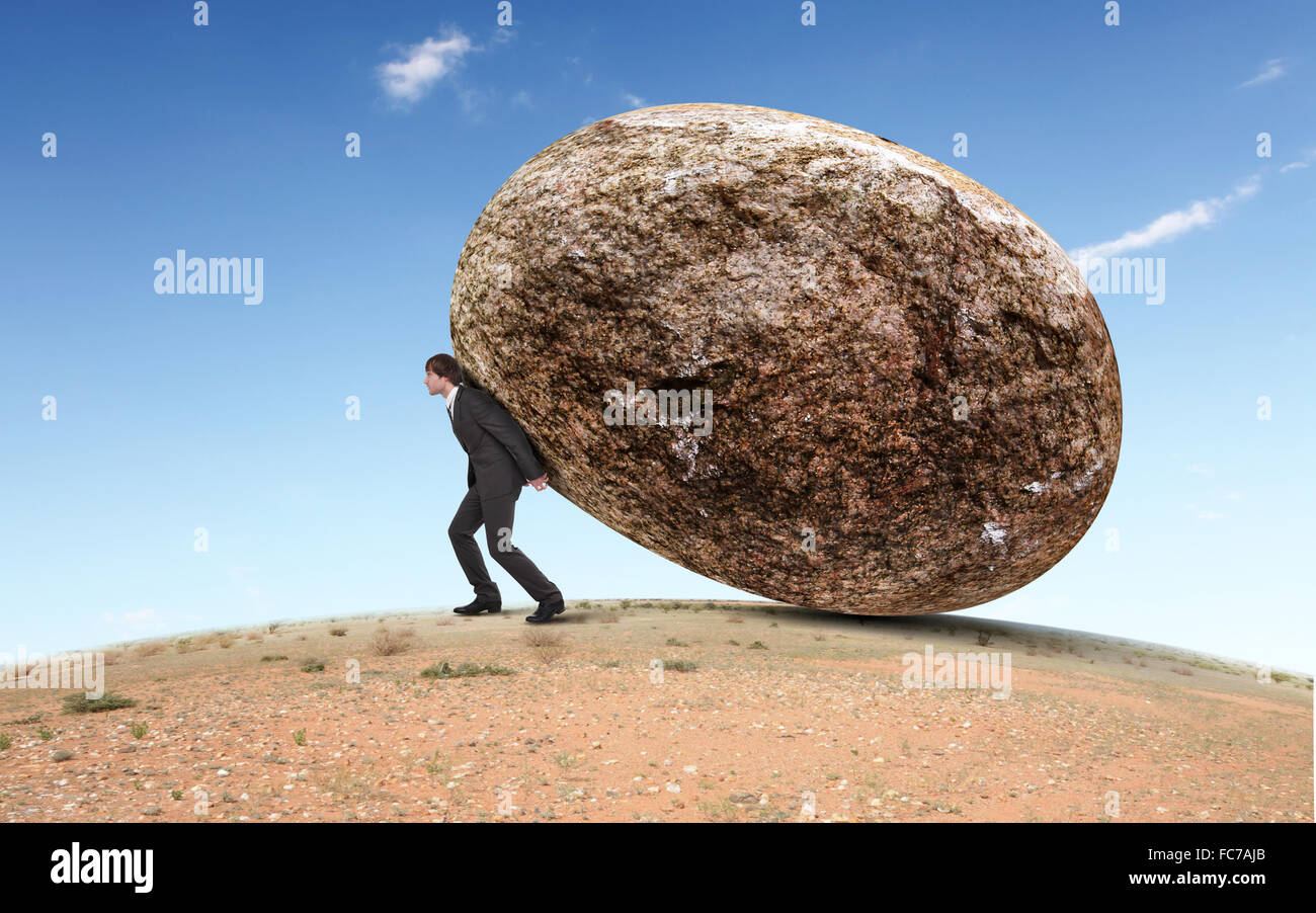 Bild der Geschäftsmann einen riesigen Stein ins Rollen Stockfoto