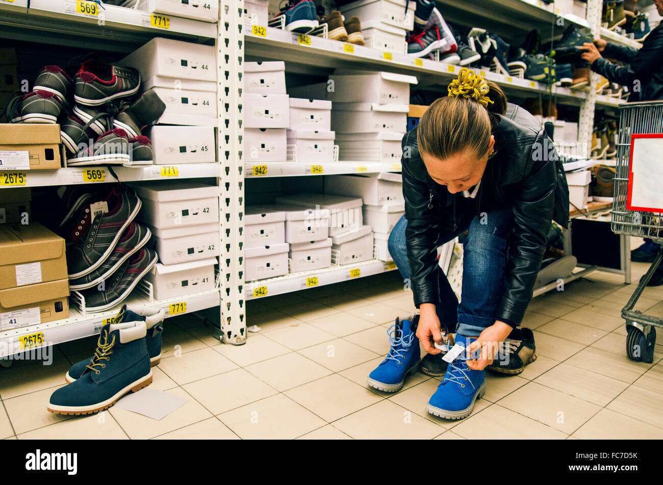 Kaukasische Frau Schuhe im Laden anprobieren Stockfoto