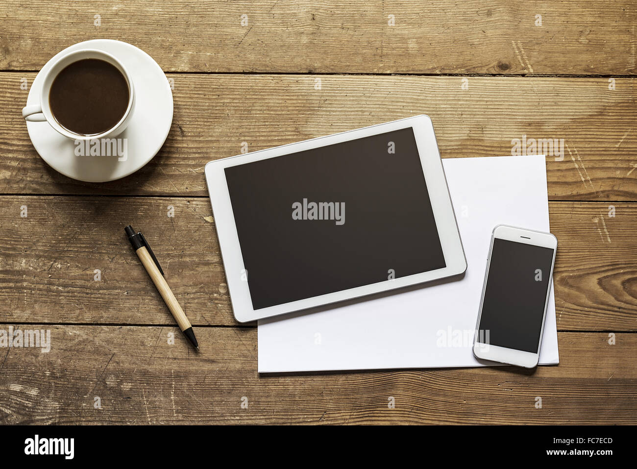 Tablet und Smartphone auf hölzernen Arbeitsbereich Stockfoto