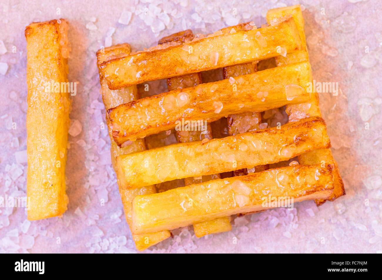 Pommes frites serviert auf einem Papier mit Salz und Öl Stockfoto
