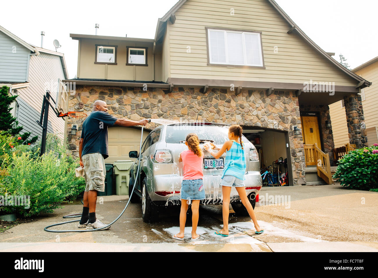Vater und Töchter Auto waschen Stockfoto