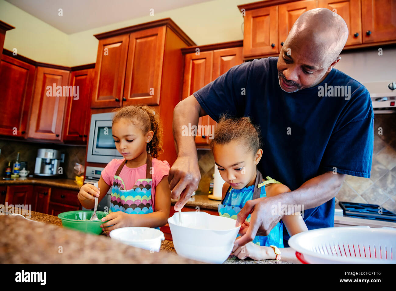 Vater und Töchter in Küche Stockfoto