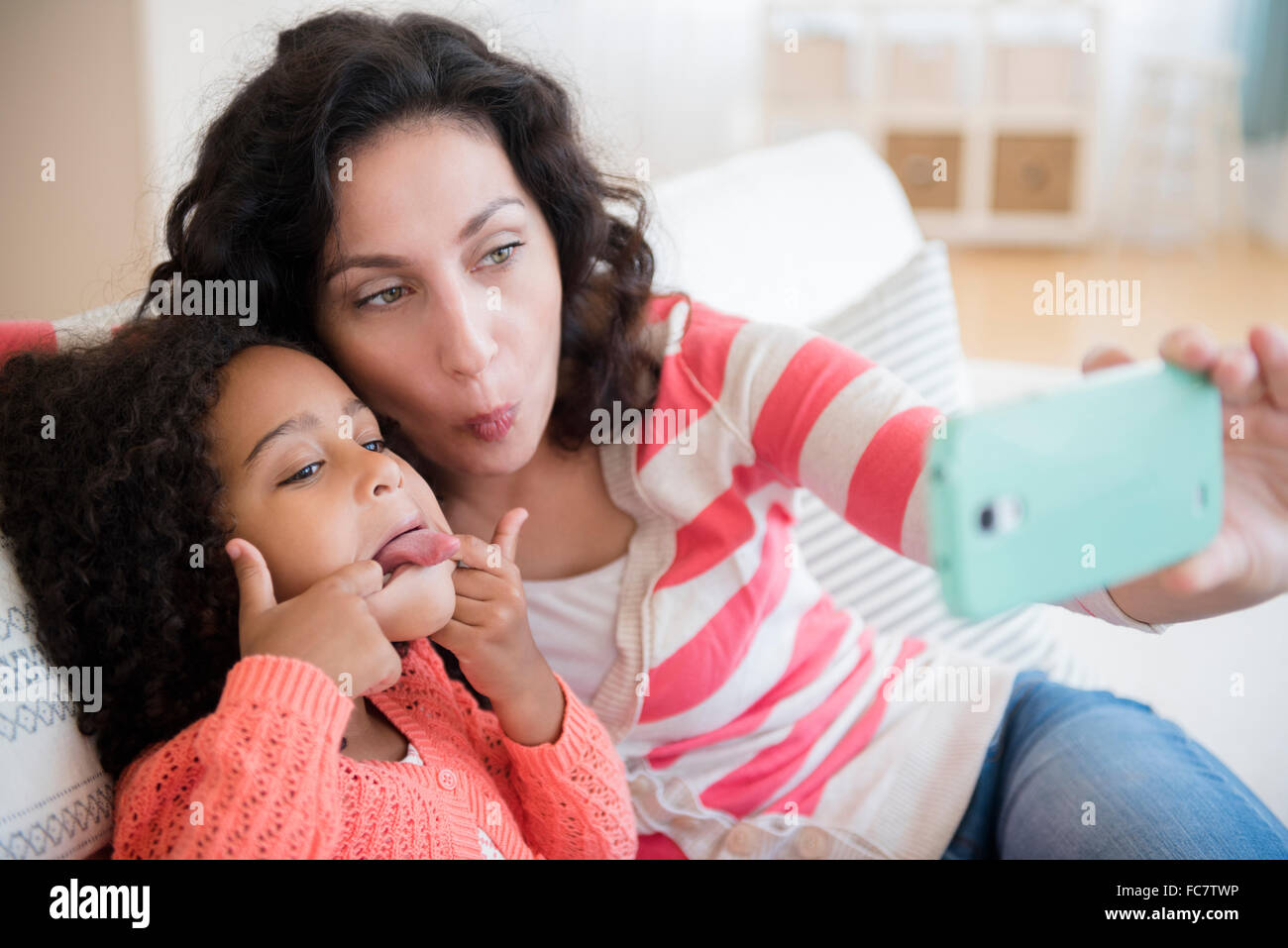 Mutter und Tochter nehmen Selfie auf sofa Stockfoto