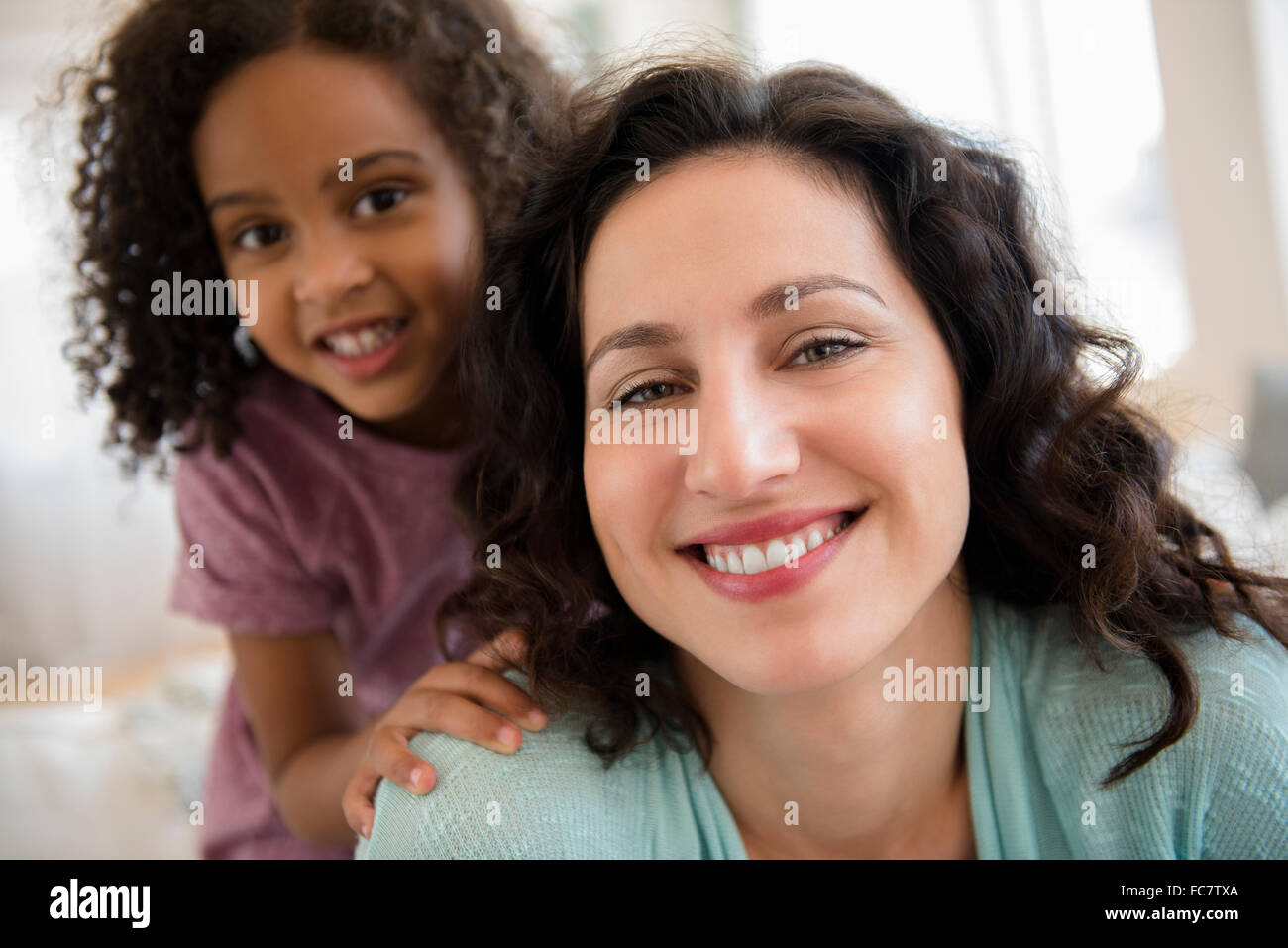 Mutter und Tochter lächelnd im Innenbereich Stockfoto