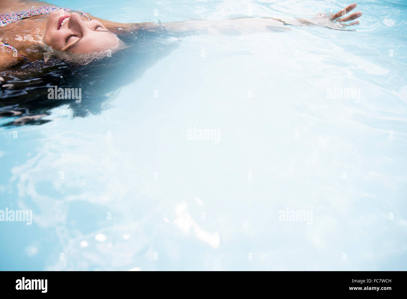 Kaukasische Frau schweben im Schwimmbad Stockfoto