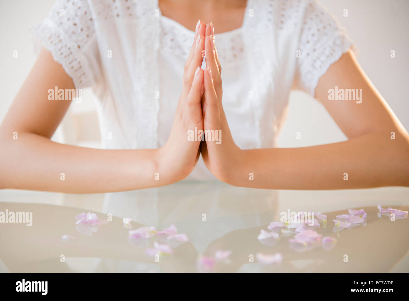 Hispanische Frau am Tisch zu meditieren Stockfoto